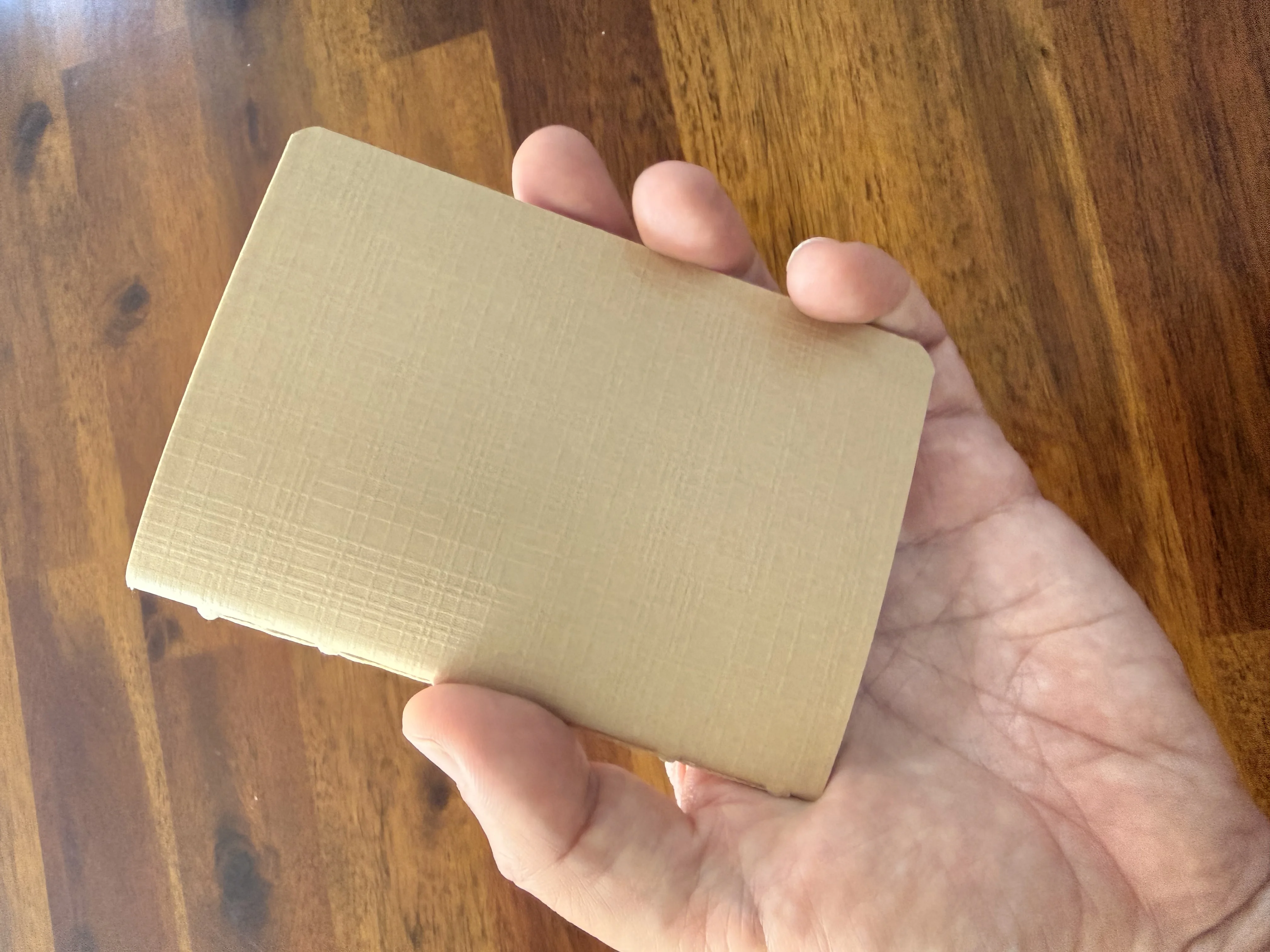 The compact textured notebook held in one hand