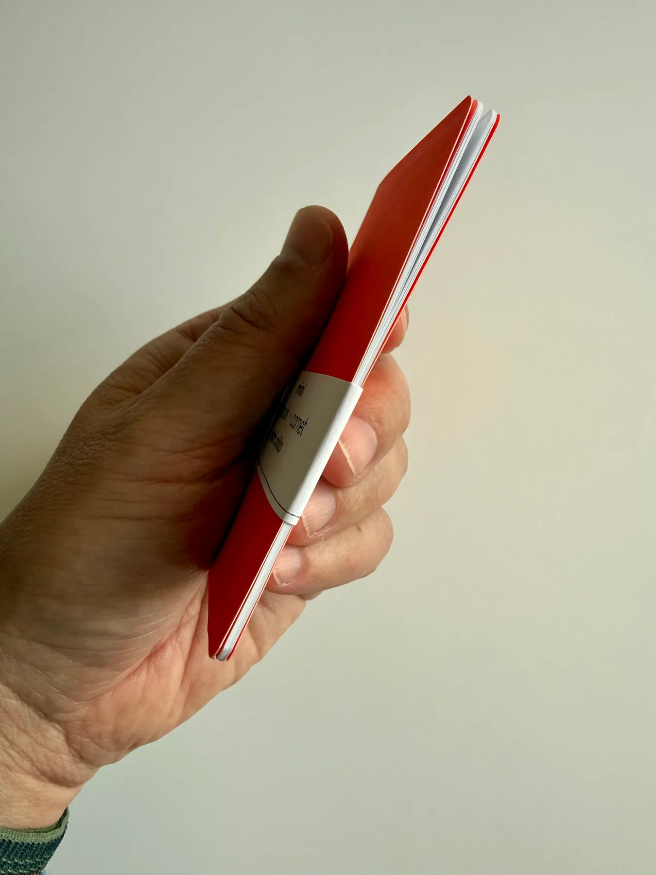 Side profile showing the slim Mīnī Neō notebook and its pages