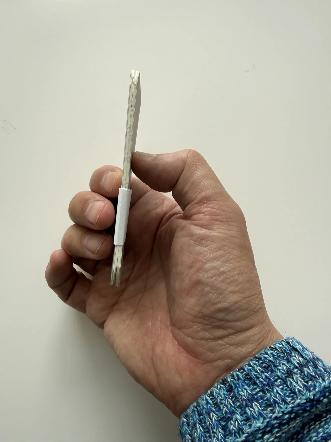 Side profile showing the slim Mīnī notebook and its pages