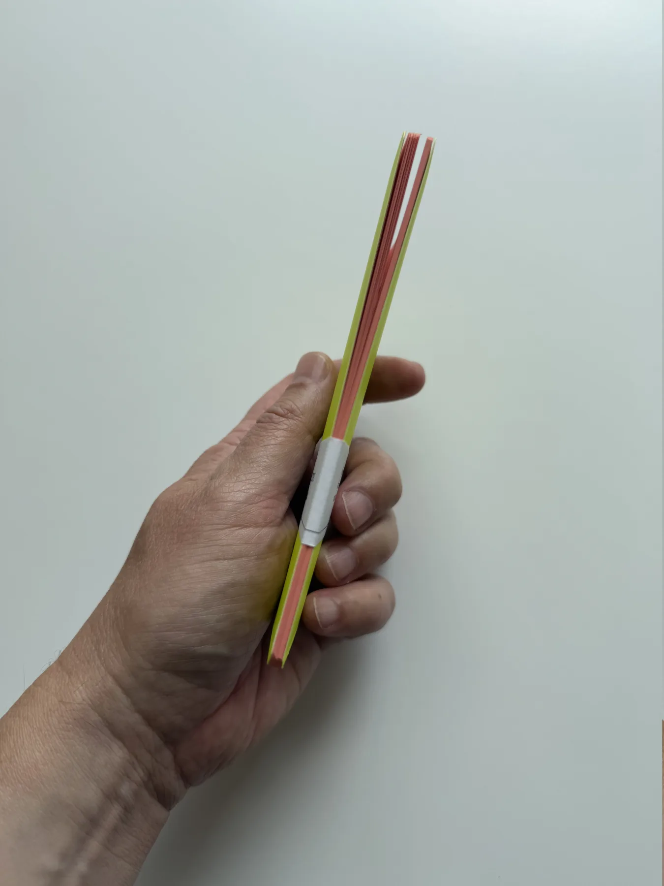Slim profile of a yellow Nōto Neō notebook with coral pages