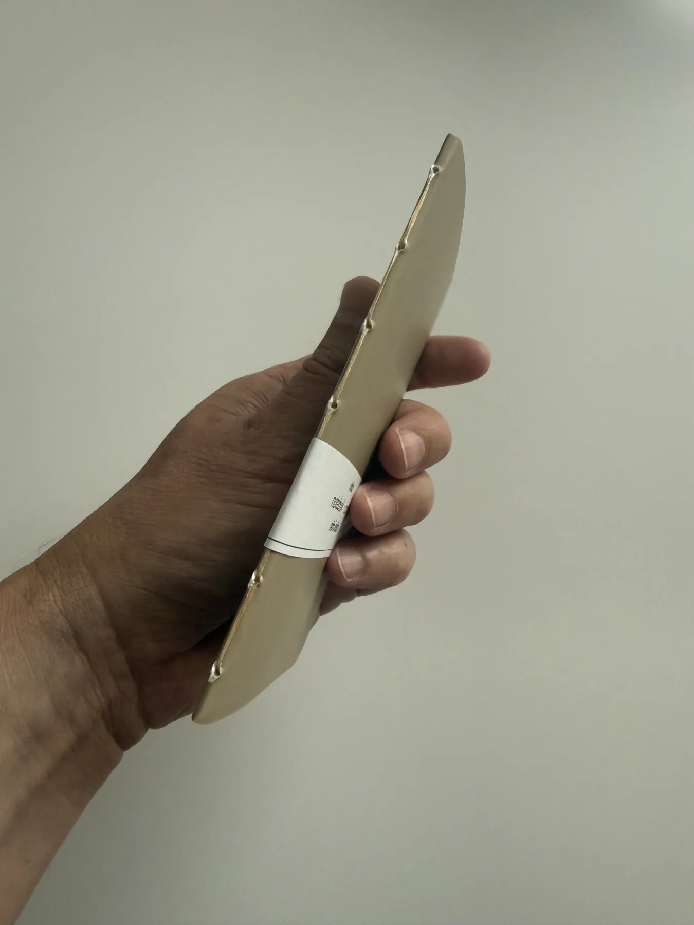 Close view of the hand stitching on a brown-paper Nōto notebook